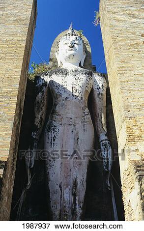 Thailand, Sukhotha, Low angle view of Standing Stone Statue Between Pillars; Wat Mahathat View Large Photo Image Stock Photo - Thailand, Sukhotha, Low angle view of Standing Stone Statue Between Pillars; Wat Mahathat. Fotosearch