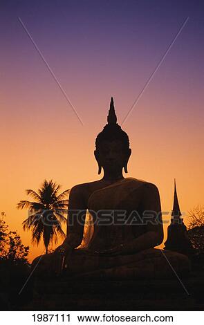 Thailand, Sukhothai, Wat Mahathat At Sunset, Silhouetted Buddha Statue, Purple And Orange Sky. View Large Photo Image Stock Image - Thailand, Sukhothai, Wat Mahathat At Sunset, Silhouetted Buddha Statue, Purple And Orange Sky.. Fotosearch