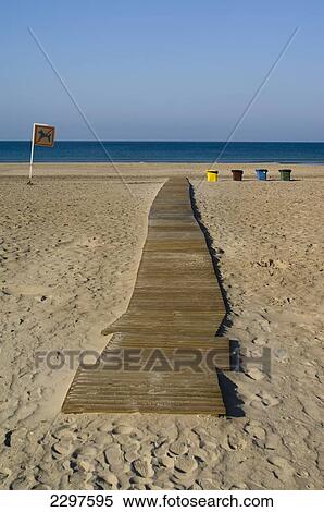 Stock Photography - The beaches of the Atlantic Coast of southern Spain - the Costa de La Luz. Walkway, colour-coded recycling bins and No Dogs sign in Zahara de los Atunes, Andalucia, Spain. Fotosearch