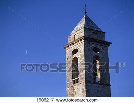 Stock Photo - The Belltower Of The Church Of Santo Stefano Di Sessanio With The Moon Behind At Dusk, Abruzzo, Italy.. Fotosearch