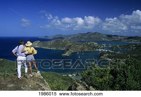 Stock Photography - The Caribbean, Antigua, Shirley Heights Lookout, Couple Overlooking Scenic Bay And Harbor.. Fotosearch