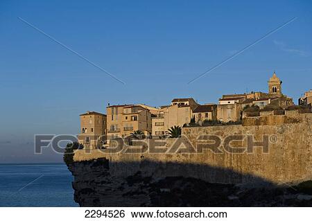 Stock Photograph - The first rays of sunlight hitting the medieval fortified town of Bonifacio. Corsica. France. Fotosearch