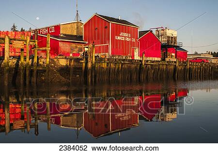 Stock Image - The fishing plant reflected in the Columbia River at the port of Ilwaco; Ilwaco, Washington, United States of America. Fotosearch