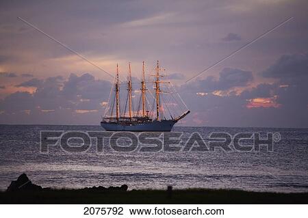 Stock Image - The Four-Mast Barquentine, Esmeralda That Is The Chilean Navy Training Ship In Hanga Roa Harbour At Dusk, Rapa Nui (Easter Island), Chile. Fotosearch
