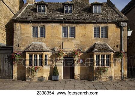 Picture - The Front Of A House With A Door And Hanging Flower Baskets; England. Fotosearch