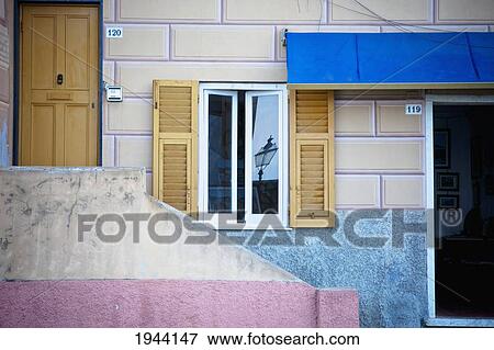 Stock Photo - The Front Of A House With A Door And Open Window; Genoa Liguria Italy. Fotosearch