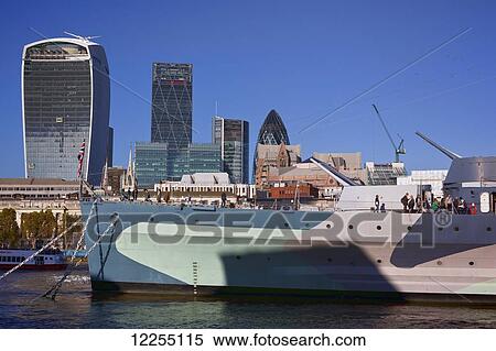 Stock Photography - The HMS Belfast, WWII battleship, and the buildings of the City of London, the financial district, with the River Thames; London, England. Fotosearch