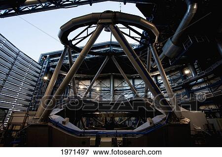 Stock Photo - The Last Rays Of The Sun Illuminate Part Of The Mechanical Structure Of Moon Unit Telescope 2, Belonging To The Very Large Telescope (Vlt) Operated By The European Southern Observatory On Cerro Paranal, Antofagasta Region, Chile. Fotosearch