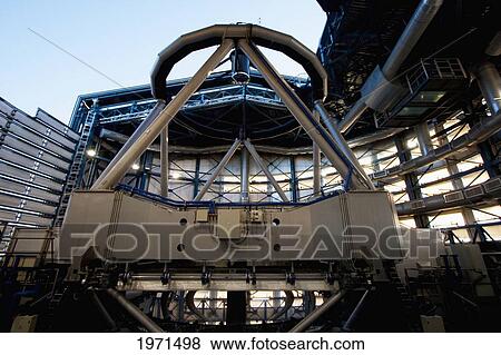 Stock Photo - The Last Rays Of The Sun Illuminate Part Of The Mechanical Structure Of Moon Unit Telescope 2, Belonging To The Very Large Telescope (Vlt) Operated By The European Southern Observatory On Cerro Paranal, Antofagasta Region, Chile. Fotosearch