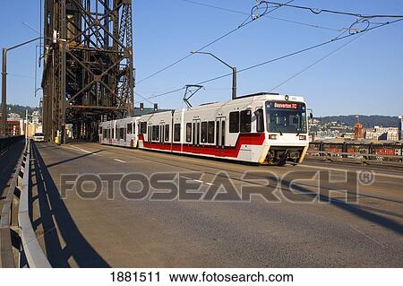 Stock Image - The Max Light Rail Train Going On Steel Bridge Over The Willamette River; Portland, Oregon, United States Of America. Fotosearch
