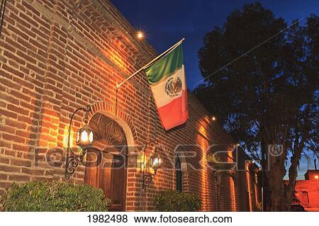 Stock Photo - The Mexican Flag Hangs Above The Doorway Of A Building Downtown; Todos Santos Baja California Sur Mexico. Fotosearch