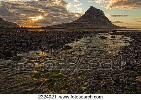 The mountain Kirkjufell rises above the ocean as the sun sets on the Snaefellsnes peninsula; Iceland View Large Photo Image Stock Image - The mountain Kirkjufell rises above the ocean as the sun sets on the Snaefellsnes peninsula; Iceland. Fotosearch