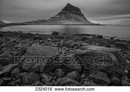 Stock Photograph - The mountain Kirkjufell rises above the ocean near the town of Grundarfjordur, Snaefellsnes peninsula; Iceland. Fotosearch