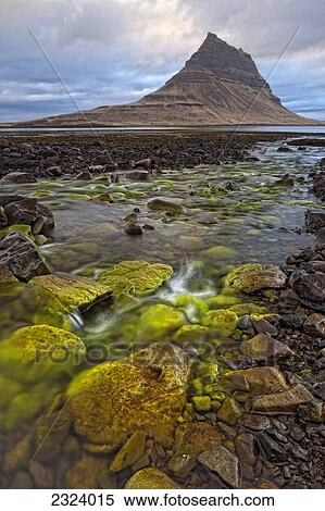 The mountain Kirkjufell rises above the ocean near town of Grundarfjorour, Snaefellsnes Peninsula; Iceland View Large Photo Image Stock Photography - The mountain Kirkjufell rises above the ocean near town of Grundarfjorour, Snaefellsnes Peninsula; Iceland. Fotosearch