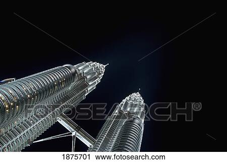 Stock Image - The Petronas Twin Towers And The Pedway Between Them Illuminated At Night; Kuala Lumpur, Malaysia. Fotosearch