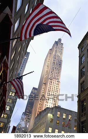 Stock Image - The Rockefeller Centre At Night With The American Flag In Front. Fotosearch