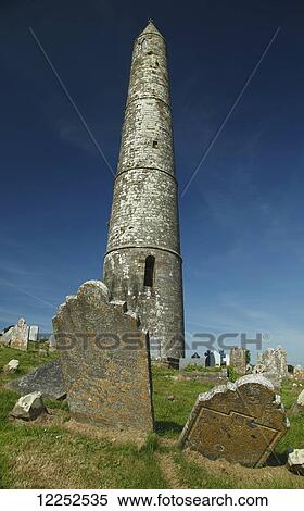 Stock Photography - The round tower and cemetery in Ardmore village; Ardmore, County Waterford, Ireland. Fotosearch