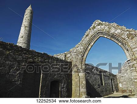 Picture - The round tower and ruins of the cathedral in Ardmore village; Ardmore, County Waterford, Ireland. Fotosearch