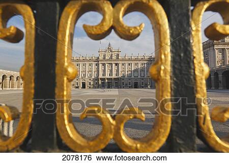 Stock Photograph - The Royal Palace As Seen Through Gold Painted Details Of A Metal Fence; Madrid Spain. Fotosearch
