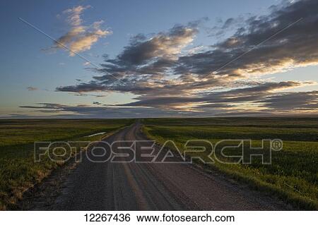 Stock Photograph - The sun rises at dawn in the Grasslands National Park; Saskatchewan, Canada. Fotosearch