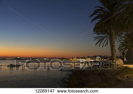 Stock Photo - The sun setting over the harbour; Paphos, Cyprus. Fotosearch