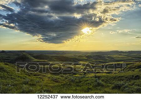 The sun shines through a cloud over the Killdeer Badlands, Grasslands National Park; Saskatchewan, Canada View Large Photo Image Stock Photo - The sun shines through a cloud over the Killdeer Badlands, Grasslands National Park; Saskatchewan, Canada. Fotosearch