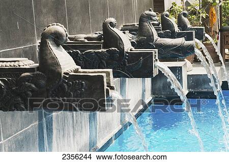 Picture - The swimming pool at the Dwarika Hotel in the style of a twelfth century Malla Dynasty bath, the water spouts are from the Lichhavi period; Nepal. Fotosearch