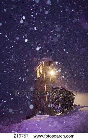 Stock Image - The tiny church of the Pyrenees' ski resort La Mongie, in France on a snowy night.. Fotosearch