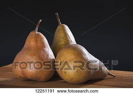 Three bosc pears on a wooden cutting board with a black background View Large Photo Image Stock Image - Three bosc pears on a wooden cutting board with a black background. Fotosearch