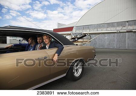 Stock Image - Three businessmen sitting in the backseat of a car; Langley, British Columbia, Canada. Fotosearch