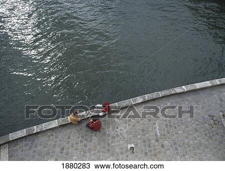Stock Image - Three Friends Sitting On Banks Of River Seine. Fotosearch