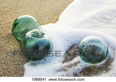 Three Glass Fishing Floats Roll On The Sandy Shoreline With Ripples Of Water And Seafoam View Large Photo Image Stock Image - Three Glass Fishing Floats Roll On The Sandy Shoreline With Ripples Of Water And Seafoam. Fotosearch