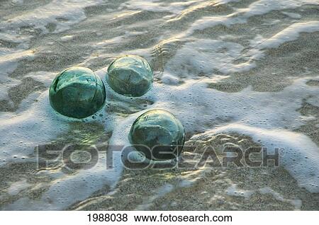Stock Photo - Three Glass Fishing Floats Rolling In Shallow Water. Fotosearch