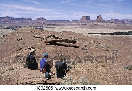 Three Hikers Relaxing On Rock At White Rim View Large Photo Image Stock Photograph - Three Hikers Relaxing On Rock At White Rim. Fotosearch
