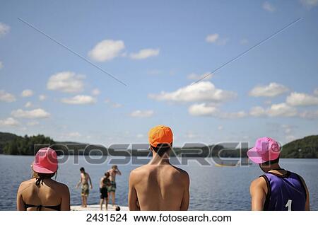 Picture - Three lifeguards stand watch over the waters of Lake Vernon; Muskoka, Ontario, Canada. Fotosearch