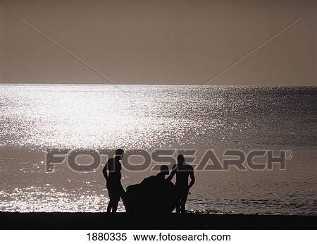 Stock Photography - Three Men In Silhouette And Boat On The Beach. Fotosearch