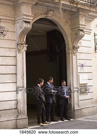 Stock Image - Three Mid-Adult Men Standing In Entrance Gate; Rome, Italy. Fotosearch