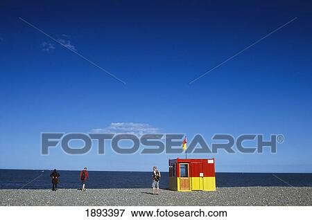 Three People Near Lifesaving Station On Beach, Rear View View Large Photo Image Stock Photo - Three People Near Lifesaving Station On Beach, Rear View. Fotosearch