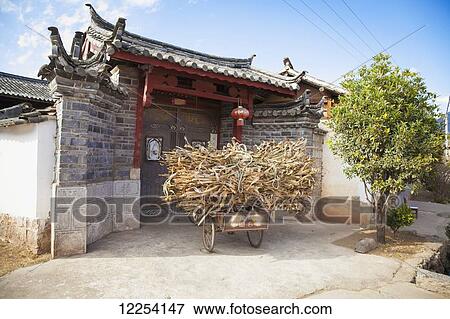 Stock Photo - Three wheeled Chinese bicycle outside traditional house gate; Lijiang, Yunnan Province, China. Fotosearch