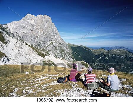 Stock Image - Three Woman Resting On Ridge In Front Of Corno Grande. Fotosearch