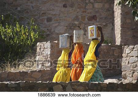 Three Women In Saris Carrying Boxes On Their Heads View Large Photo Image Stock Photo - Three Women In Saris Carrying Boxes On Their Heads. Fotosearch
