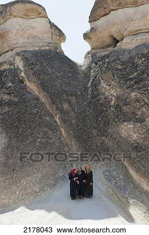 Three Women Standing At The Base Of A Large Rock Formation; Nevsehir Turkey View Large Photo Image Stock Image - Three Women Standing At The Base Of A Large Rock Formation; Nevsehir Turkey. Fotosearch