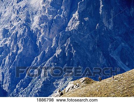 Stock Photo - Three Women Walking Along Ridge In Front Of The South East Face Of Corno Grande. Fotosearch