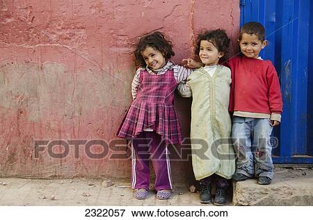 Stock Photo - Three young children standing against wall; Old Medina, Casablanca, Morocco. Fotosearch