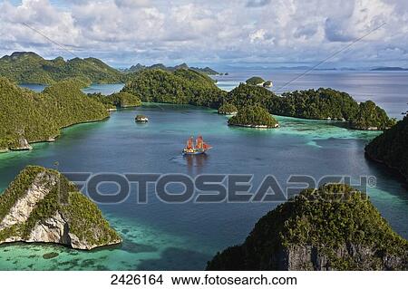 Picture - Tiger Blue Phinisi schooner sailing through Pulau Wayag Islands of Raja Ampat; Indonesia. Fotosearch