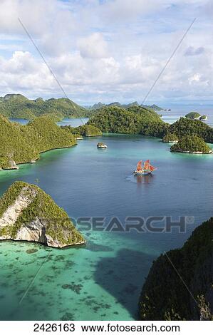 Tiger Blue Phinisi schooner sailing through Pulau Wayag Islands of Raja Ampat; Indonesia View Large Photo Image Stock Image - Tiger Blue Phinisi schooner sailing through Pulau Wayag Islands of Raja Ampat; Indonesia. Fotosearch