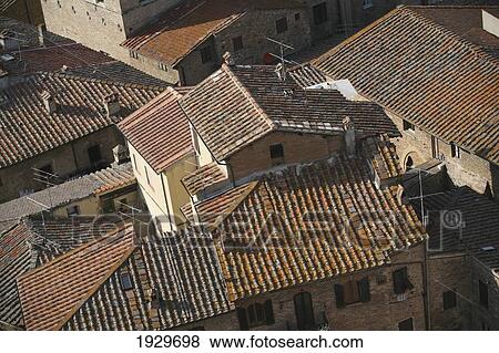 Stock Photo - Tiled rooftops viewed from an old tower in the centre of San Gimignano, a famous medieval hilltop town; San Gimignano, Tuscany, Italy. Fotosearch