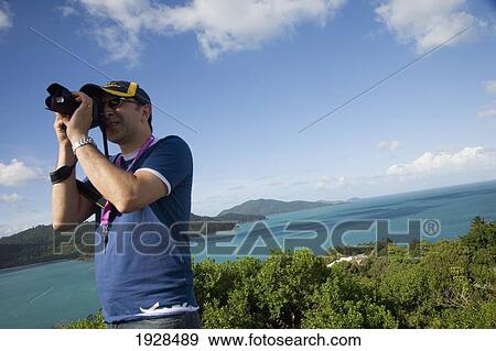 Stock Photo - Tilted Angle View Of Mountain Range And Ocean Being Photographed By Man, Australia. Fotosearch