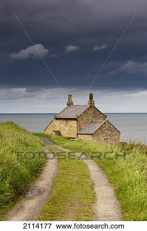 Stock Photo - Tire Tracks Worn Through The Grass Leading To A House On The Water's Edge; Northumberland England. Fotosearch