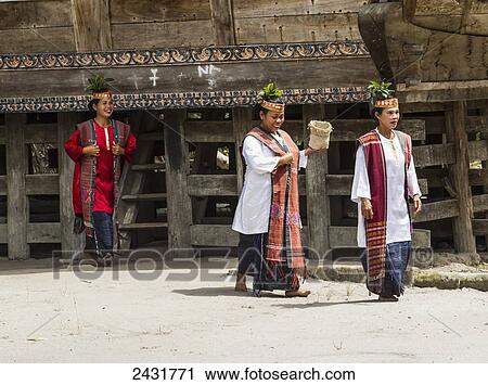 Stock Image - Toba Batak people dressed in traditional costume at Huta Bolon Museum in Simanindo village on Samosir Island, Lake Toba, North Sumatra, Indonesia. Fotosearch